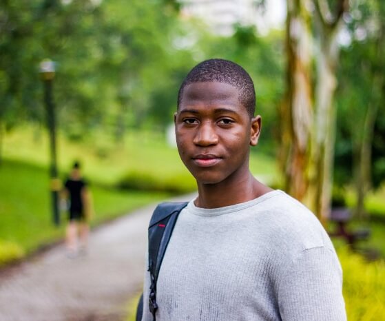 An African American youth standing in the park setting