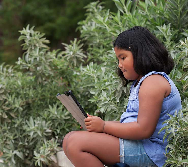 A child using a tablet in the garden