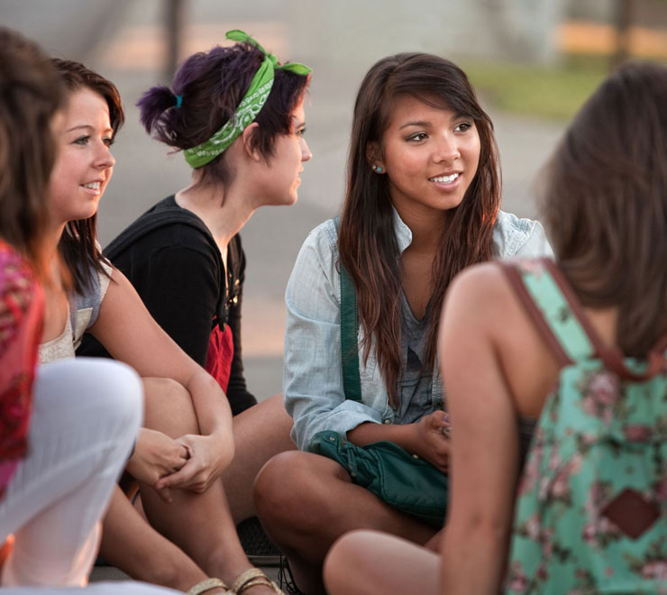 amis adolescents assis ensemble parler à l’extérieur