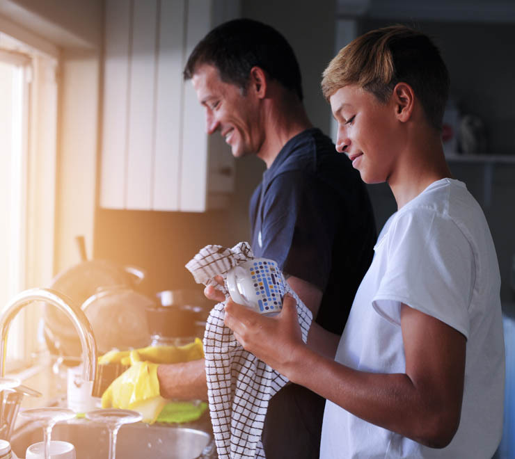 l’adolescence et les parents lavent la vaisselle ensemble